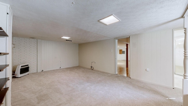 finished below grade area with carpet flooring, heating unit, and a textured ceiling