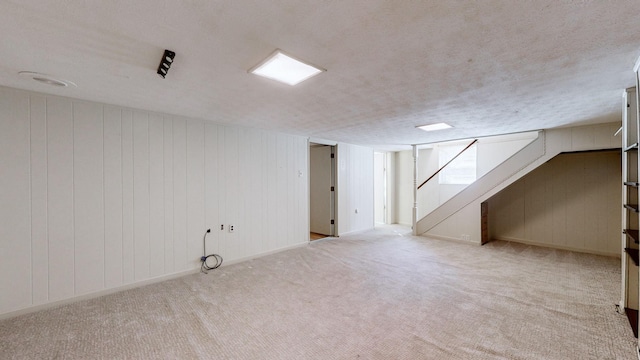 below grade area featuring stairway, a textured ceiling, and carpet flooring