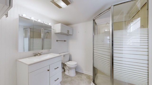 bathroom with vanity, a shower stall, and toilet