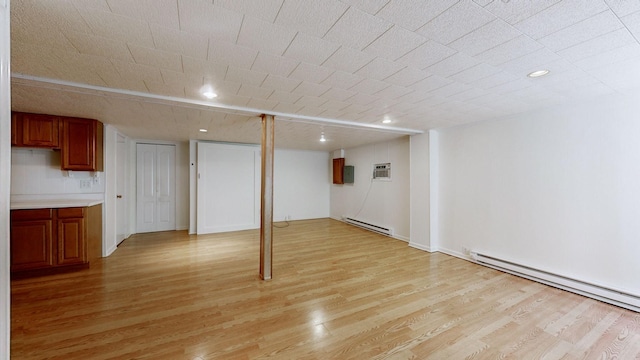 finished basement featuring a baseboard heating unit and light wood-type flooring