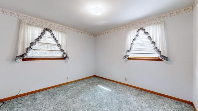 carpeted spare room with baseboards