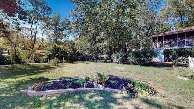 view of yard with a vegetable garden and a sunroom