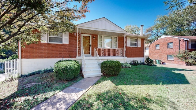 bungalow-style home with brick siding, covered porch, a front lawn, and fence