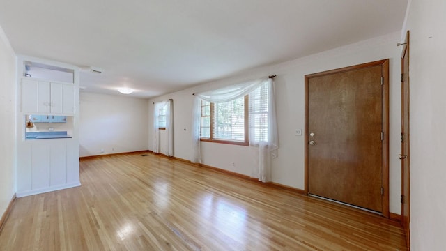 interior space featuring light wood finished floors and baseboards