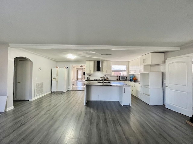 kitchen with visible vents, white fridge with ice dispenser, arched walkways, white cabinetry, and wall chimney exhaust hood