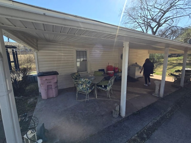 view of patio / terrace featuring an attached carport and outdoor dining area