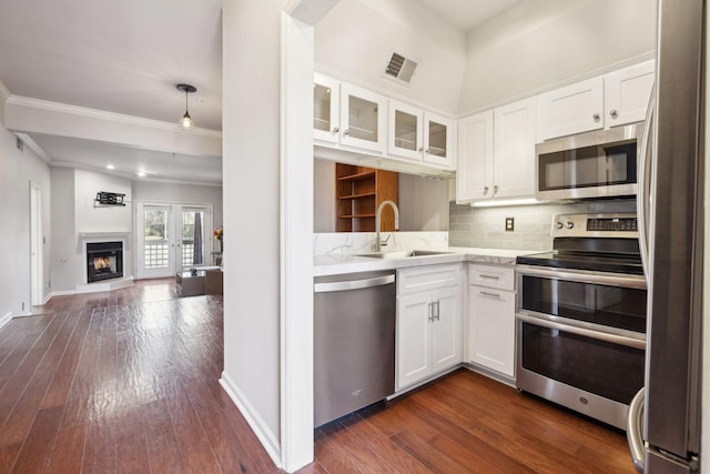 kitchen featuring visible vents, a sink, light countertops, glass insert cabinets, and appliances with stainless steel finishes