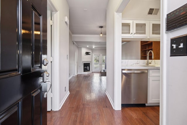 interior space with dark wood finished floors, a fireplace, visible vents, and baseboards