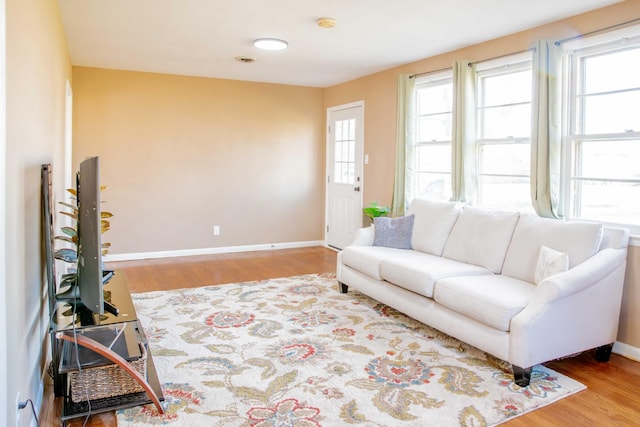 living area with baseboards and wood finished floors