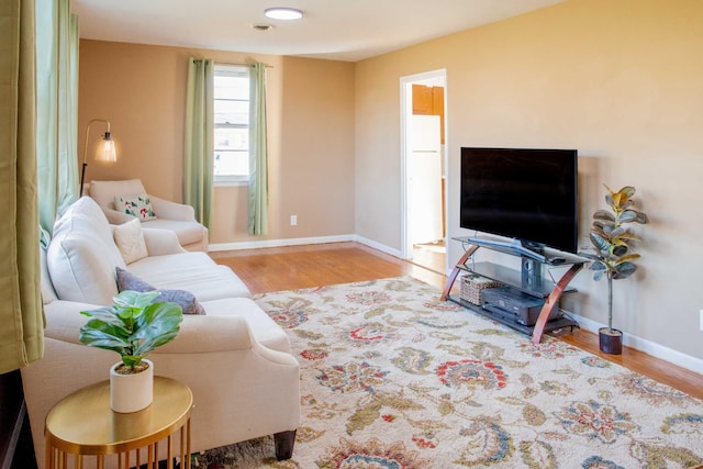 living area featuring baseboards and wood finished floors