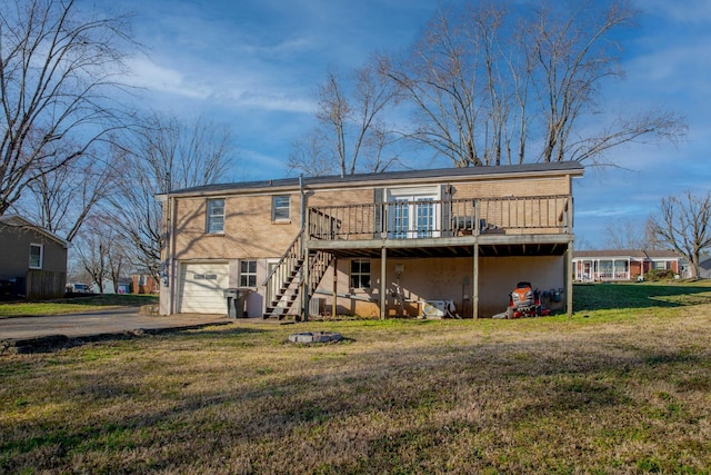 rear view of house featuring a lawn, driveway, stairway, a wooden deck, and a garage