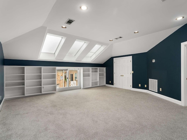 bonus room featuring lofted ceiling with skylight and visible vents