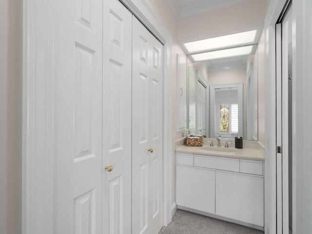 bathroom with a closet, vanity, and crown molding