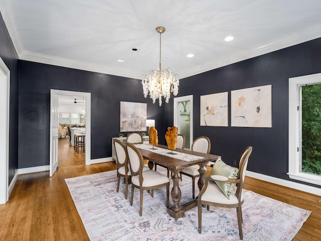 dining area with an inviting chandelier, wood finished floors, baseboards, and ornamental molding