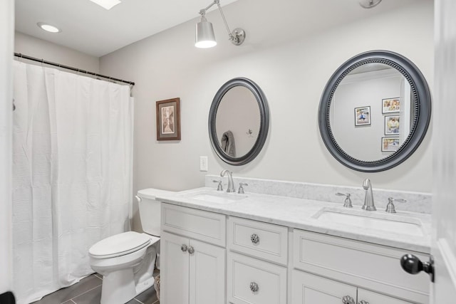 bathroom with double vanity, tile patterned floors, toilet, and a sink