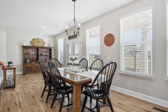 dining room with light wood-type flooring, baseboards, and visible vents