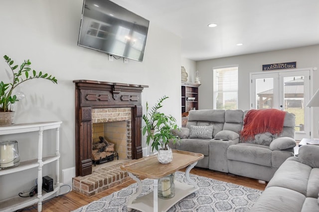 living room featuring a fireplace, recessed lighting, and wood finished floors