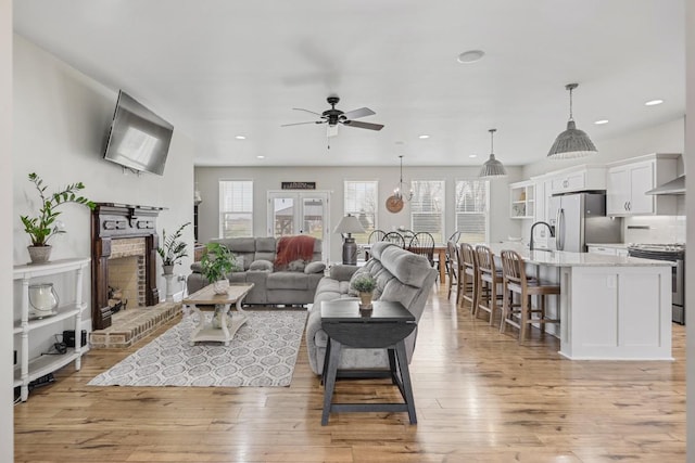 living room with recessed lighting, light wood-style flooring, and ceiling fan