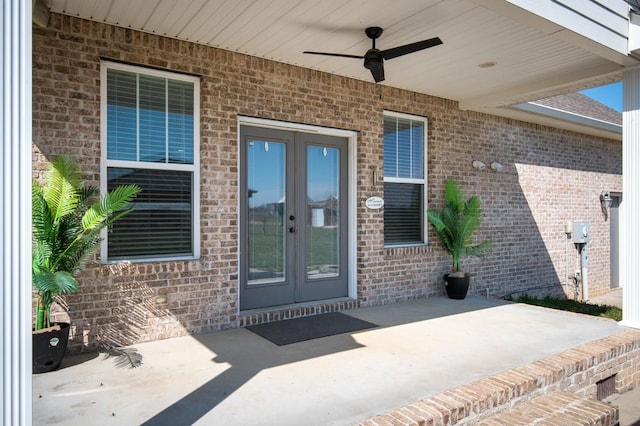 property entrance with a ceiling fan, a patio, french doors, and brick siding