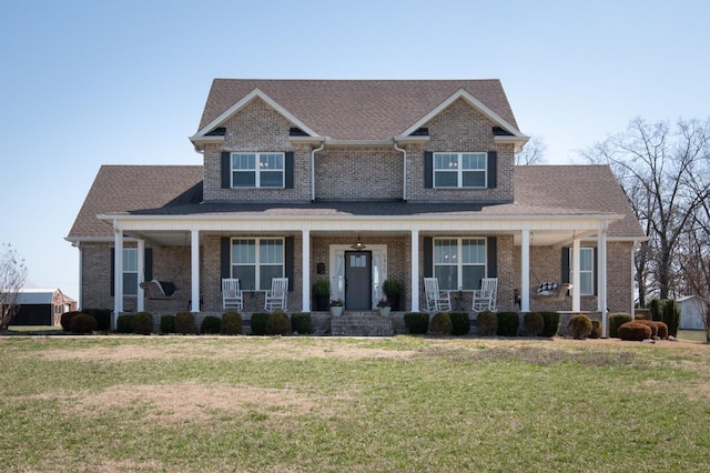 craftsman house with brick siding, covered porch, and a front yard