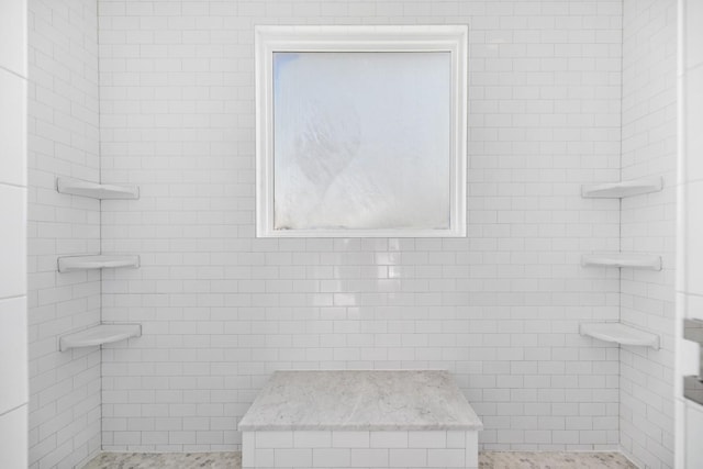 full bathroom featuring tile walls and a shower stall