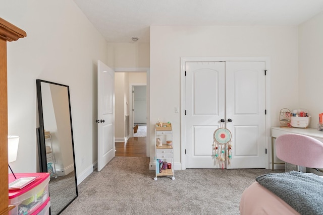 carpeted bedroom featuring a closet and baseboards