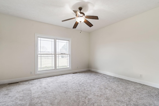 unfurnished room featuring carpet, visible vents, baseboards, ceiling fan, and a textured ceiling