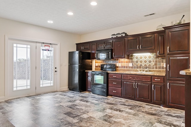 kitchen with baseboards, visible vents, a sink, black appliances, and backsplash