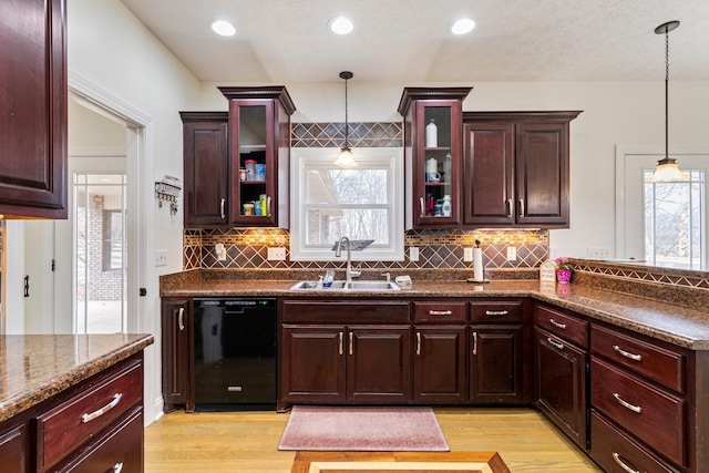 kitchen with dishwasher, pendant lighting, decorative backsplash, light wood-style flooring, and a sink