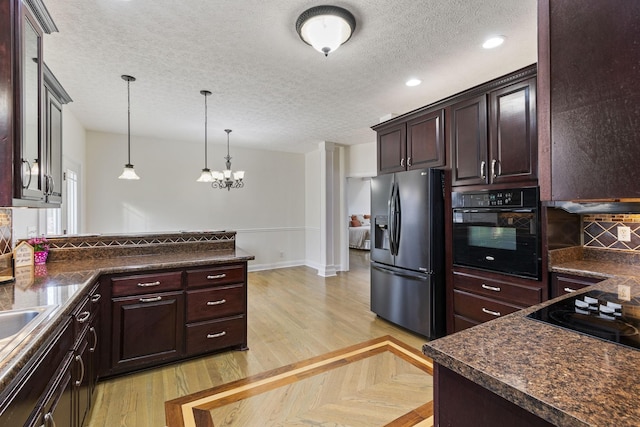 kitchen with dark countertops, pendant lighting, black appliances, and parquet floors