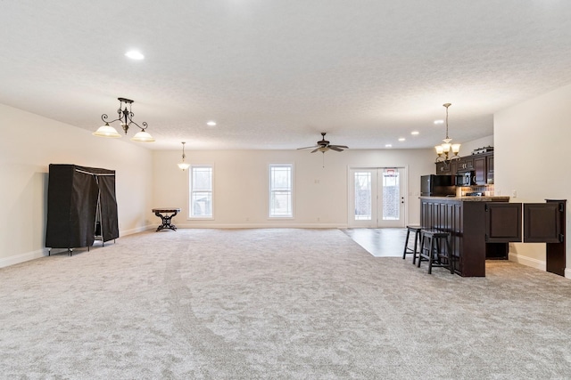 living room with a textured ceiling, recessed lighting, baseboards, and light carpet