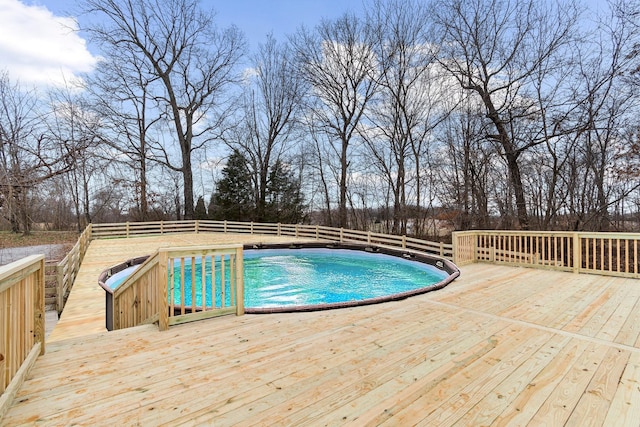 view of swimming pool with a wooden deck, a fenced in pool, and fence