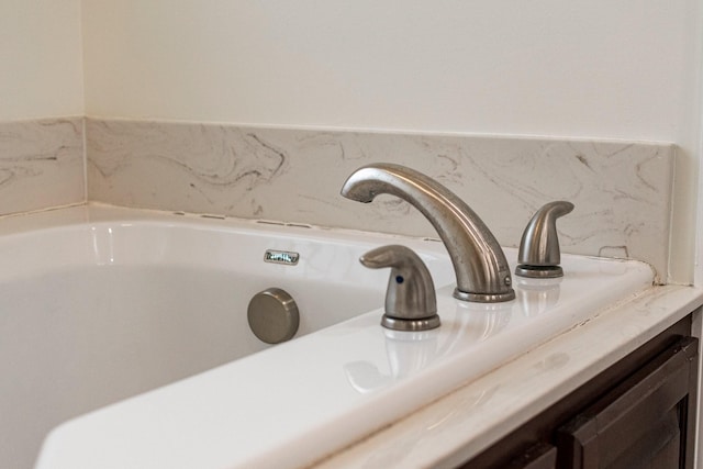 interior details featuring a bath and a sink