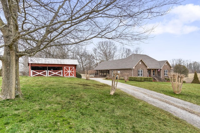 view of yard with a barn, gravel driveway, and an outdoor structure