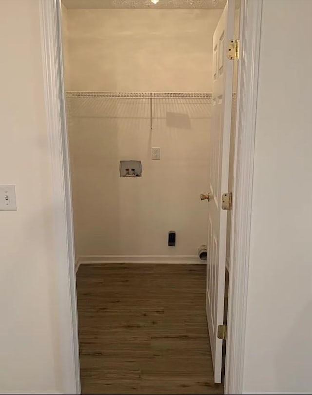 laundry room with laundry area, hookup for a washing machine, baseboards, and wood finished floors