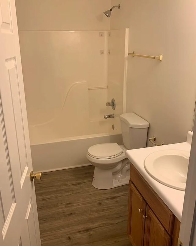 full bathroom with tub / shower combination, toilet, wood finished floors, and vanity