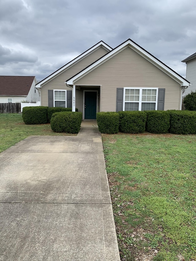 ranch-style home with a front lawn and fence