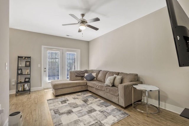 living room featuring visible vents, wood finished floors, baseboards, and ceiling fan