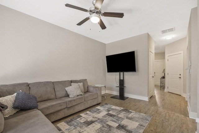 living area with visible vents, baseboards, a ceiling fan, and light wood finished floors