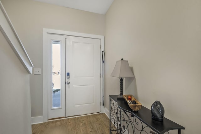 foyer with baseboards and wood finished floors