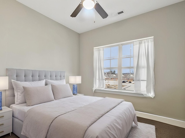 bedroom with visible vents, ceiling fan, dark carpet, and baseboards