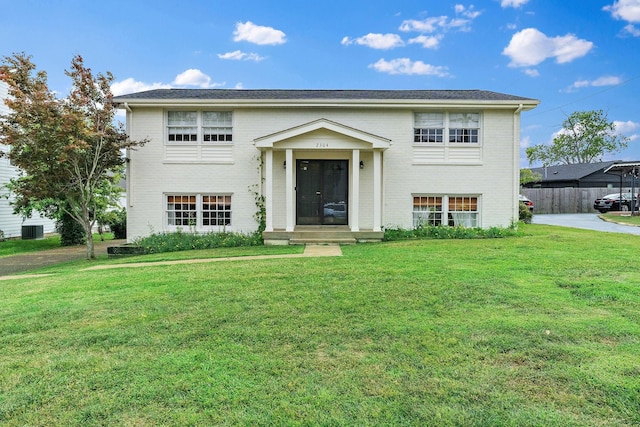 split foyer home with a front yard and brick siding