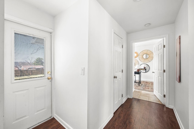 hall with baseboards and dark wood-style flooring