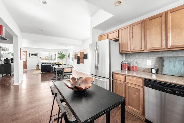 kitchen featuring tasteful backsplash, baseboards, light countertops, appliances with stainless steel finishes, and wood finished floors