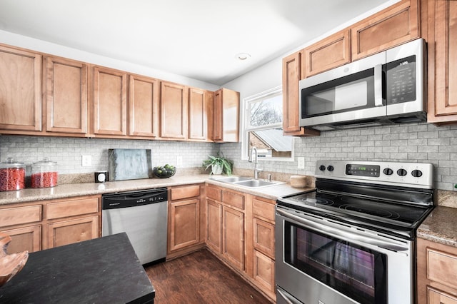 kitchen with backsplash, light countertops, dark wood-style floors, stainless steel appliances, and a sink