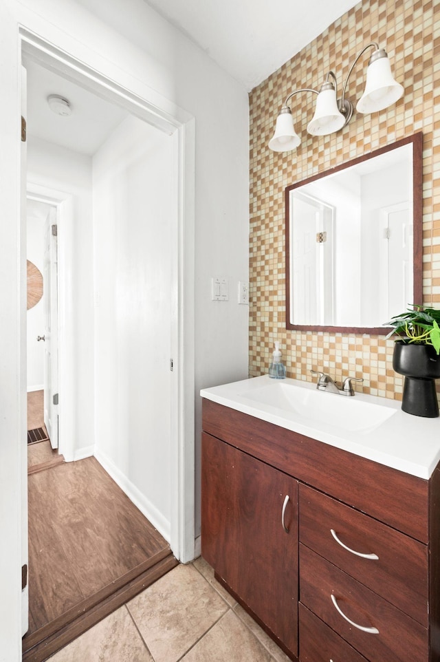 bathroom with vanity, tile patterned flooring, and backsplash