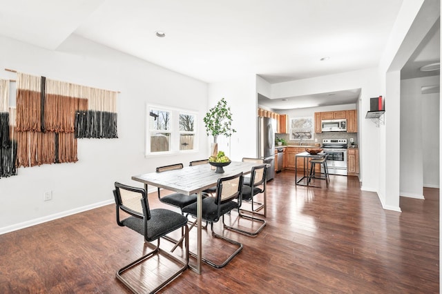 dining room with baseboards, dark wood-style flooring, and a healthy amount of sunlight