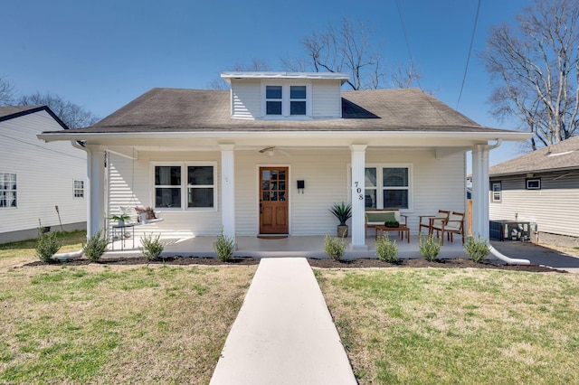 bungalow-style home with covered porch, central AC, and a front lawn