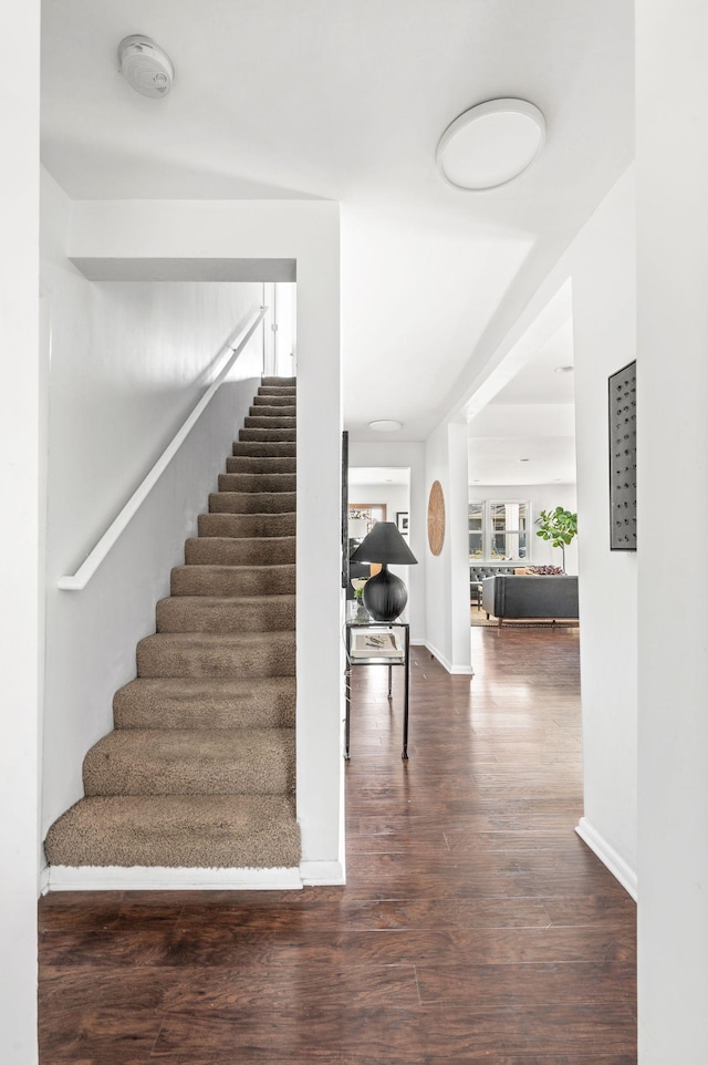 stairway with baseboards and wood finished floors