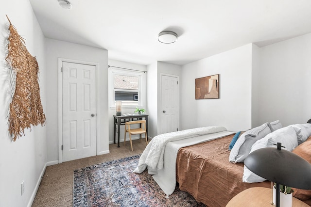 carpeted bedroom featuring baseboards and multiple closets